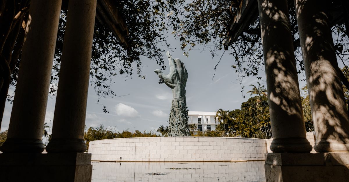 A dramatic view of the Holocaust Memorial statue framed by stone columns in Miami, Florida.